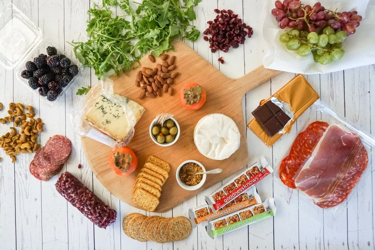 Gather ingredients around a cheese board before placing everything on it.