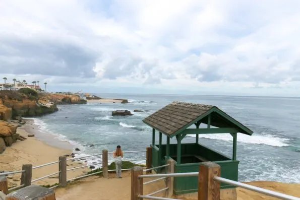My daughter looks from the upper railing down to Shell Beach.