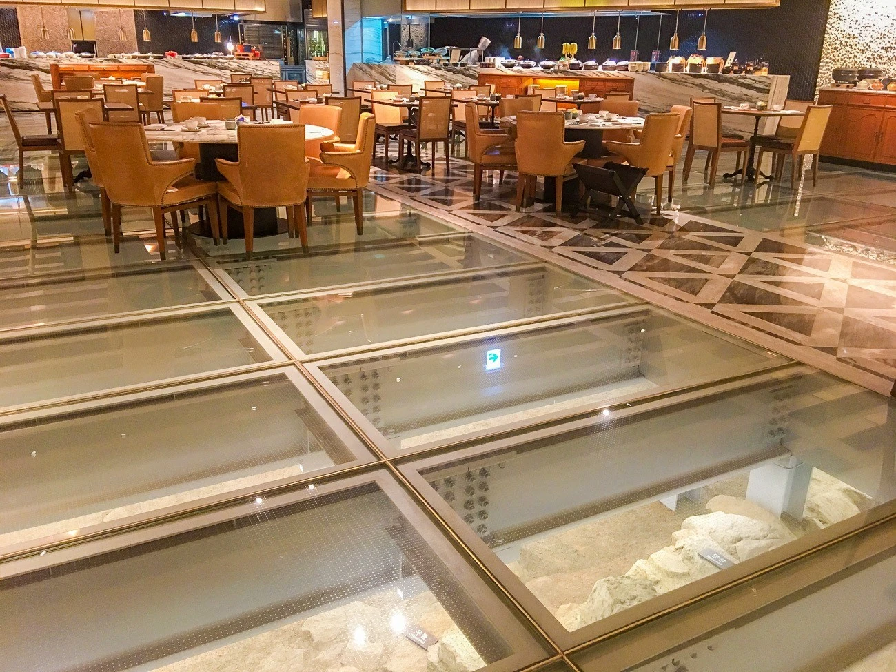 Ruins shown through glass panels in the floor of The Marketplace inside Four Seasons Hotel Seoul.