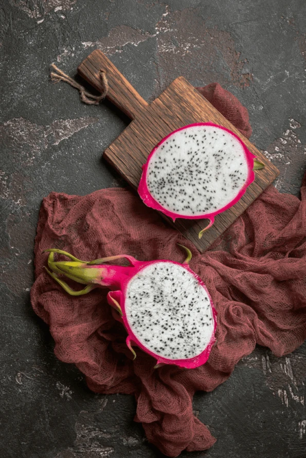 Sliced open dragonfruit on a cutting board.