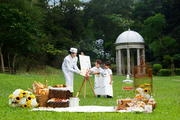 Kids painting a canvas outside with staff from The Peninsula, one of Hong Kong's best family hotels. 