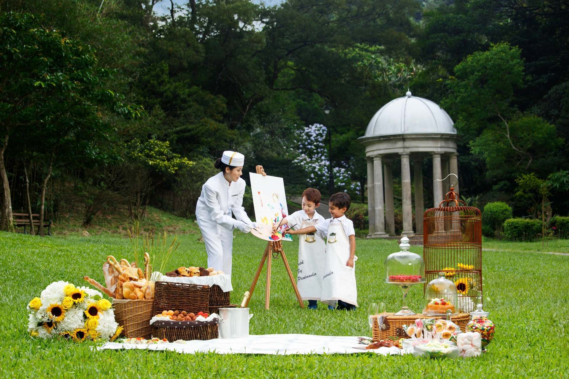 Kids painting a canvas outside with staff from The Peninsula, one of Hong Kong's best family hotels.