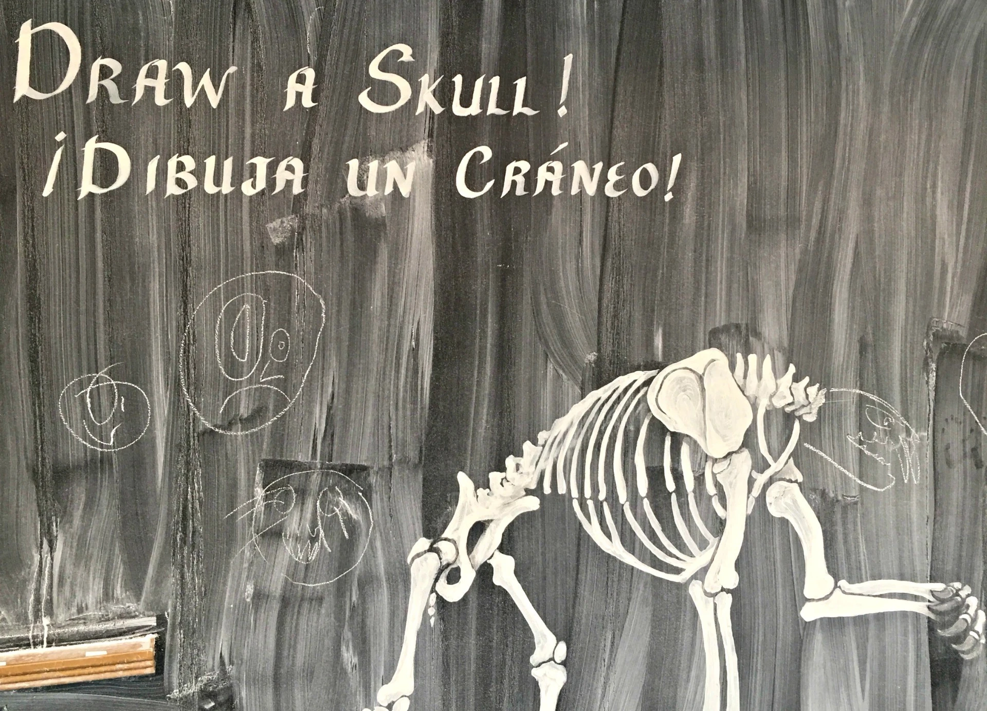 The chalkboard with text encouraging people to draw their own skulls.