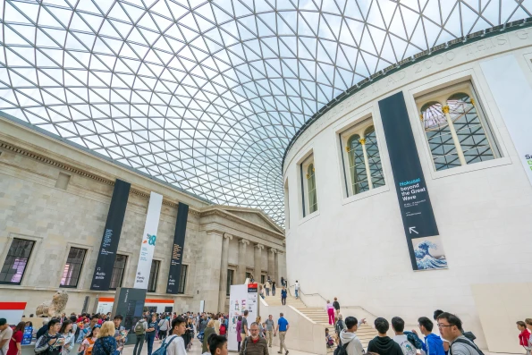 People standing under the famous atrium with its glass ceiling at the British Museum.