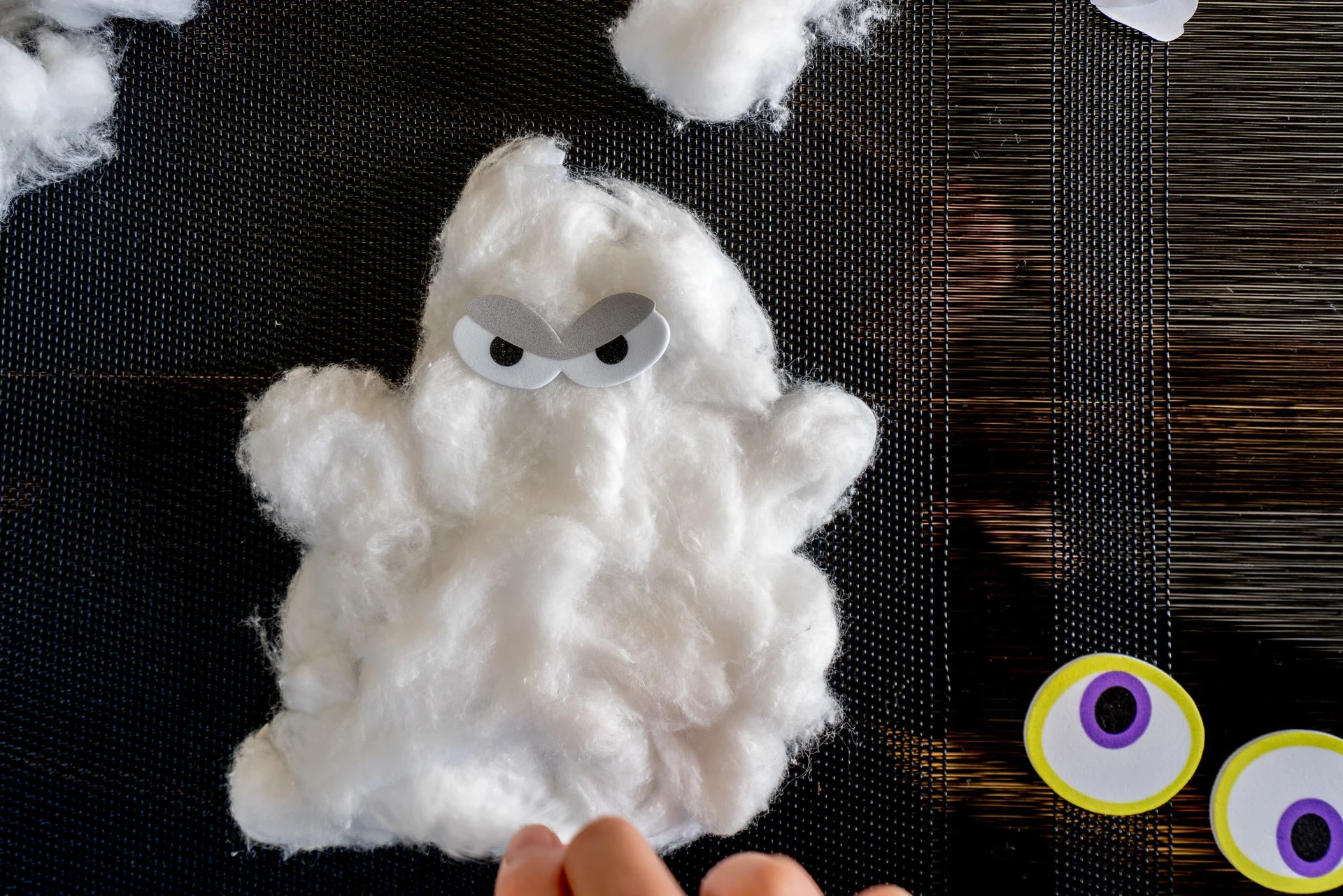 An easy Halloween craft is to make cotton ball ghosts.