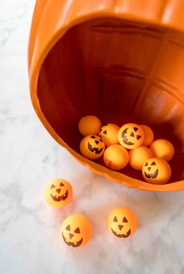 A fun toddler Halloween game is to let them throw ping pong balls into a diorama pumpkin or carved pumpkin. They can even use a foam ball and toy golf club.