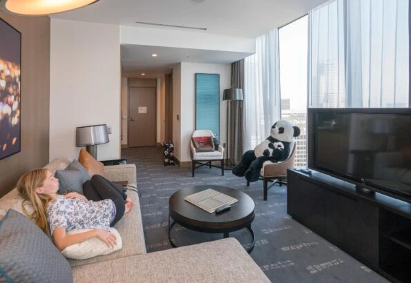 My daughter sits on the sofa in our suite's living room with the panda in another chair.