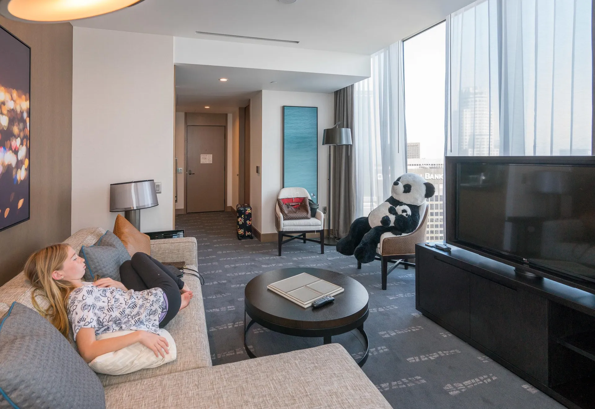 My daughter sits on the sofa in our suite's living room with the panda in another chair.