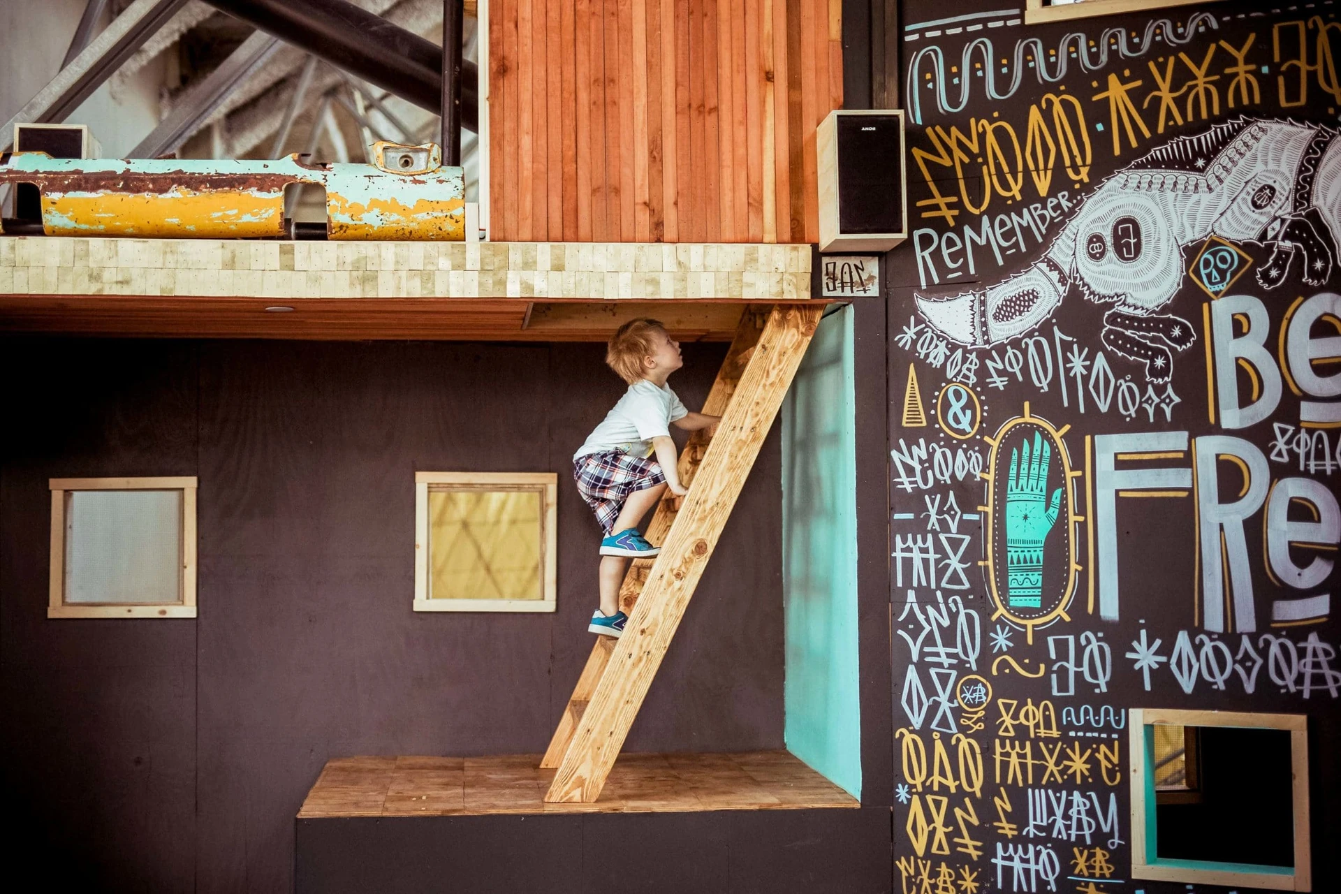 A little boy climbs a ladder in a hands-on exhibit at the New Chldren's Museum.