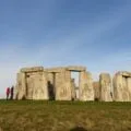 People stand at the perimeter of Stonehenge, one of the best day trips from London.