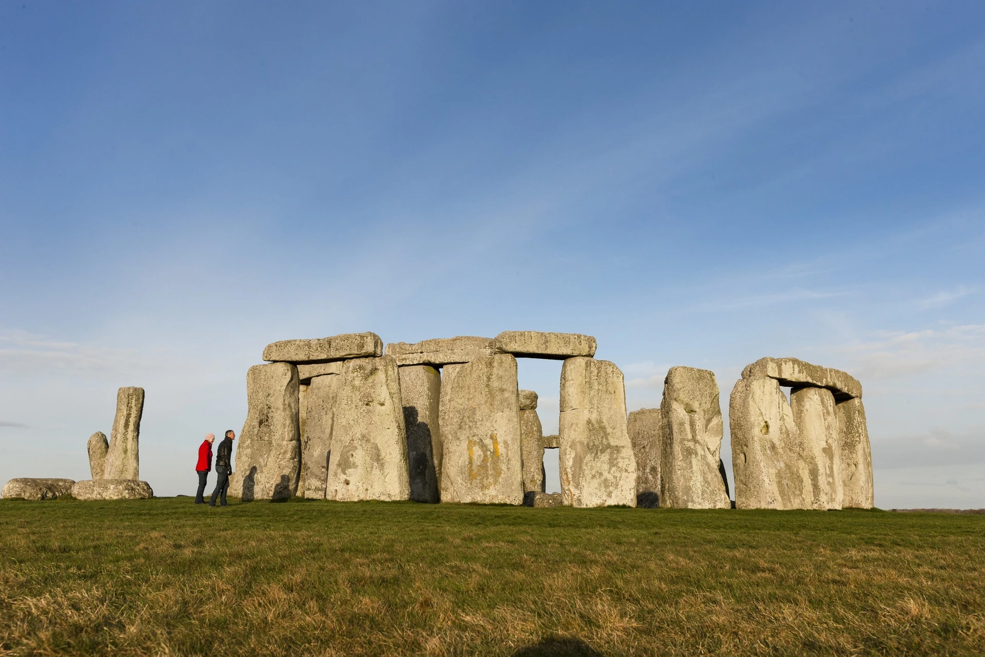 People stand at the perimeter of Stonehenge, one of the best day trips from London.
