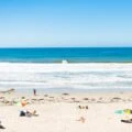 People enjoy sunbathing and surfing on a sunny day - guide to the best San Diego beaches