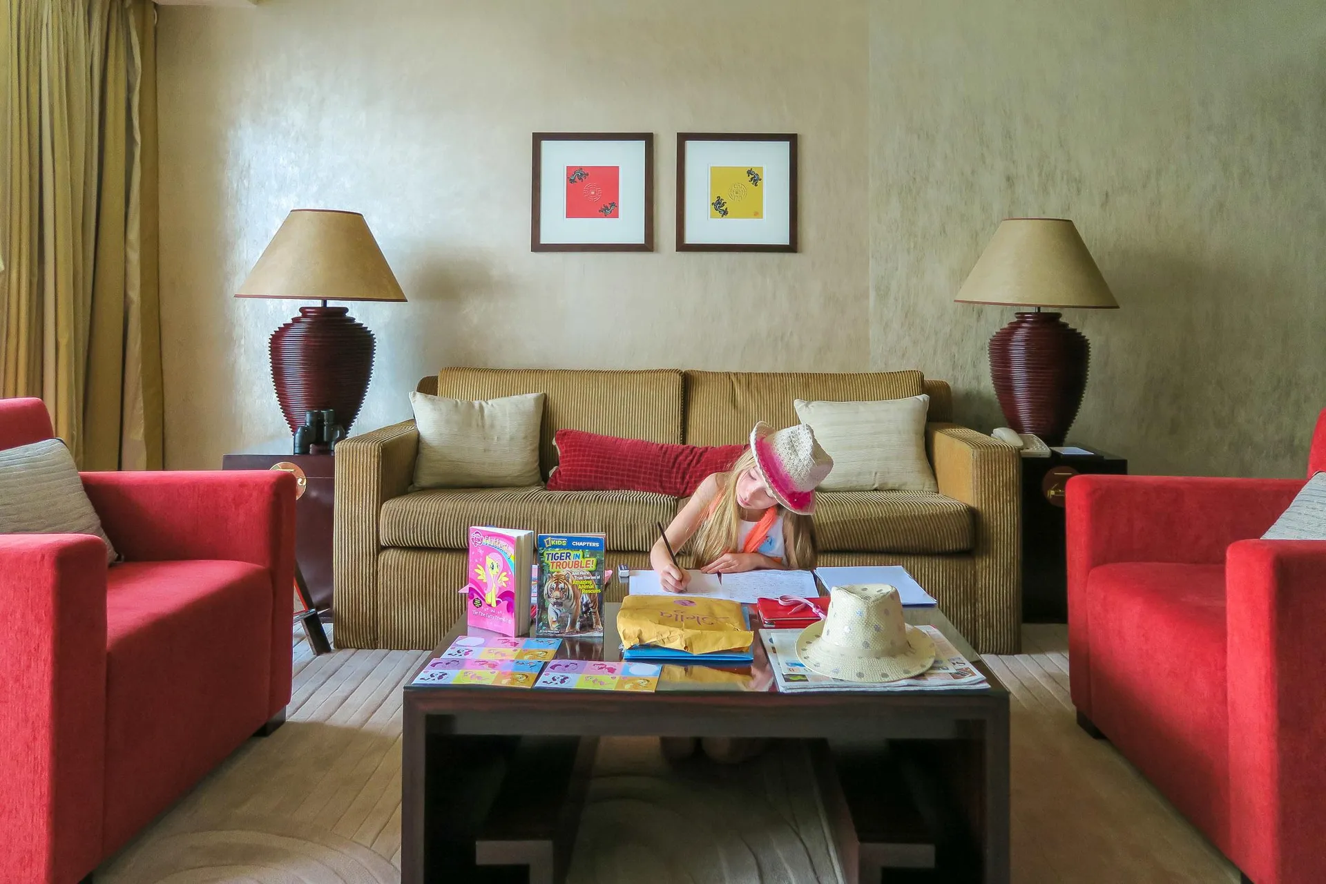 My daughter completes schoolwork on the table of a Harbour View Suite at Four Seasons Hong Kong.