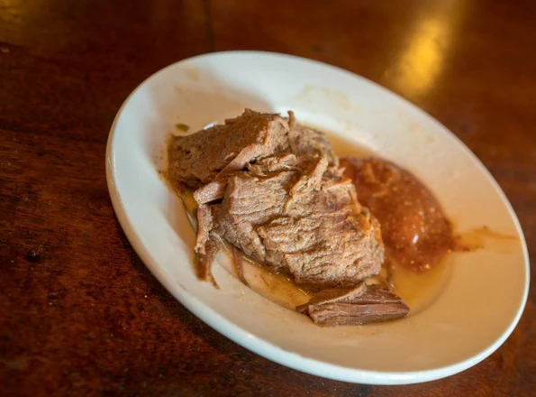 Brisket in sauce on a plate at Tujague's, New Orleans