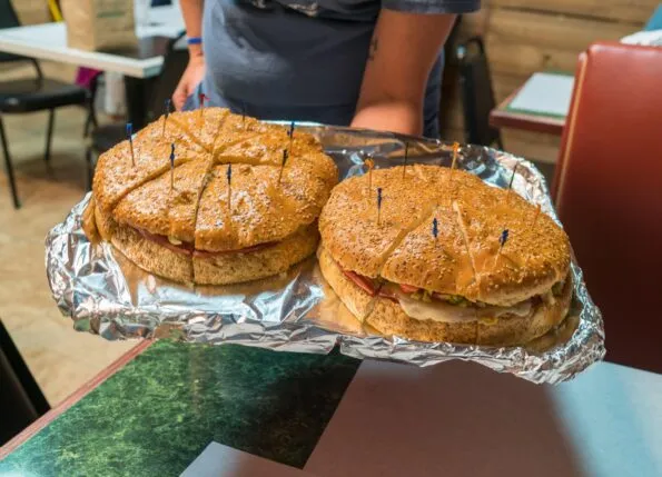 A giant muffaletta sandwich cut into sections for tasting.
