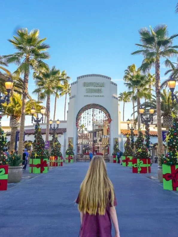 My daughter stands in front of the Universal Studios Hollywood entrance during the holiday season.