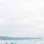 Surfers at La Jolla Shores Beach captured by a Flytographer vacation photographer.
