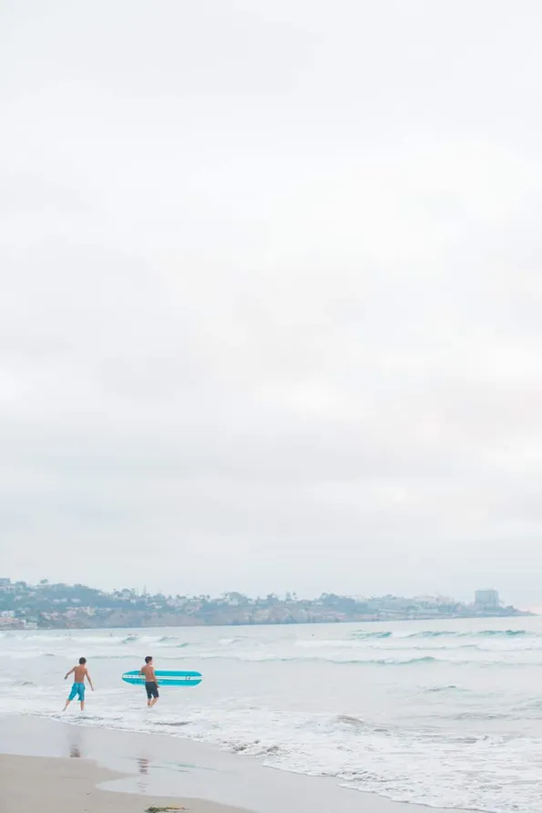 Surfers at La Jolla Shores Beach captured by a Flytographer vacation photographer.