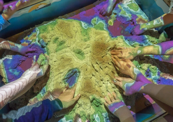 Kids play with magnetic sand in a hands-on exhibit at Birch Aquarium at Scripps.
