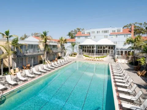 The Lafayette Hotel swimming pool surrounded by lounge chairs on a sunny day.