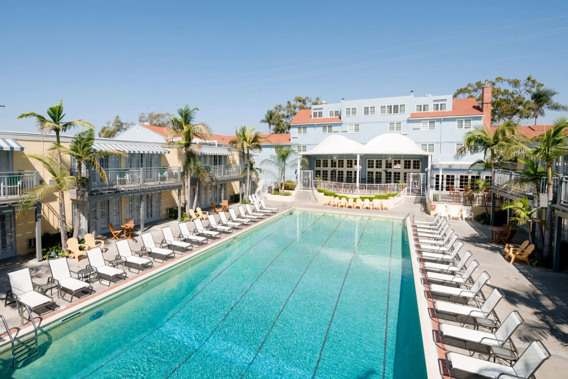 The Lafayette Hotel swimming pool surrounded by lounge chairs on a sunny day.