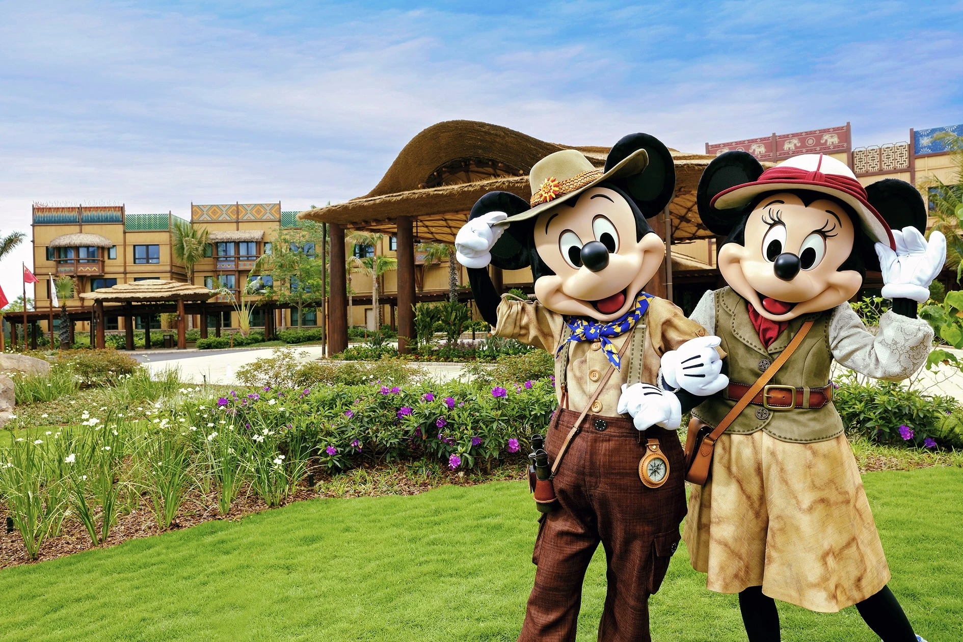 Mickey Mouse and Minnie Mouse stand in front of Disney Explorers Lodge in Hong Kong.