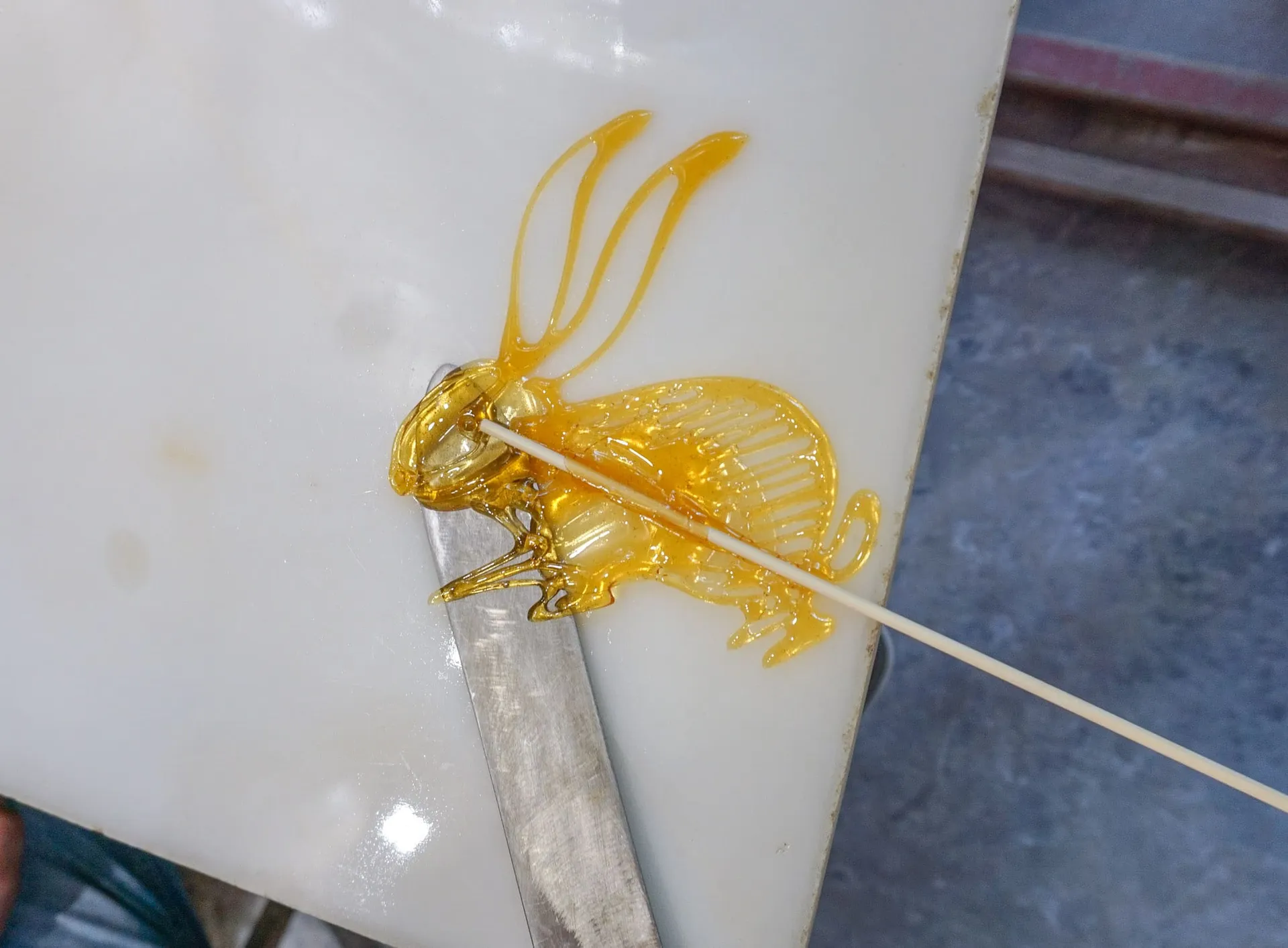 A rabbit painted with sugar being removed from the slab.