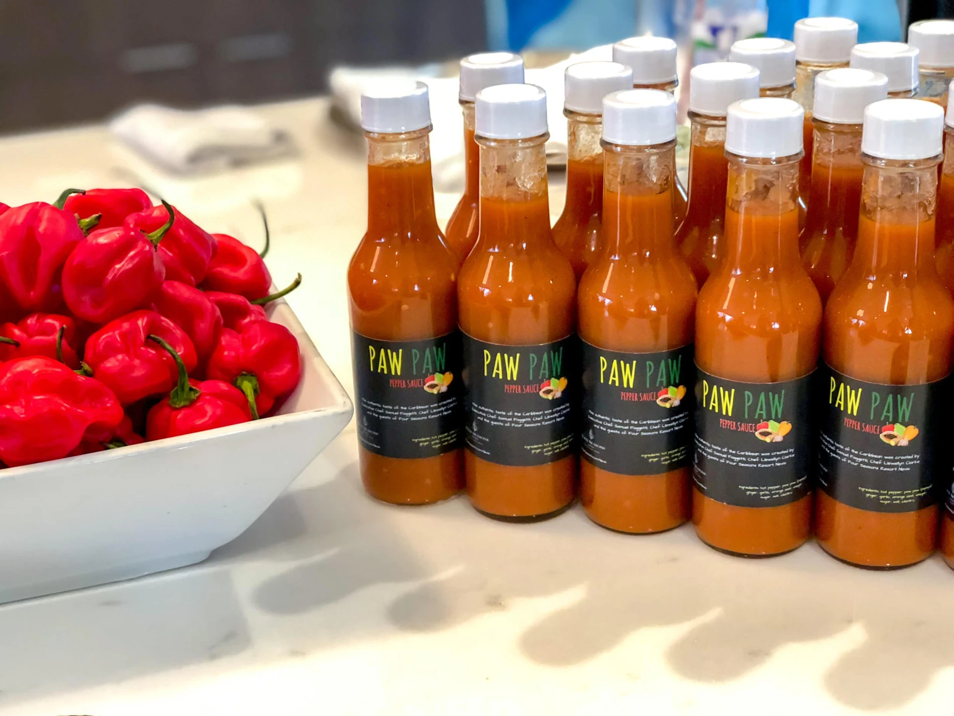 Hot sauce bottles sit on a counter during a cooking class at Four Seasons Nevis