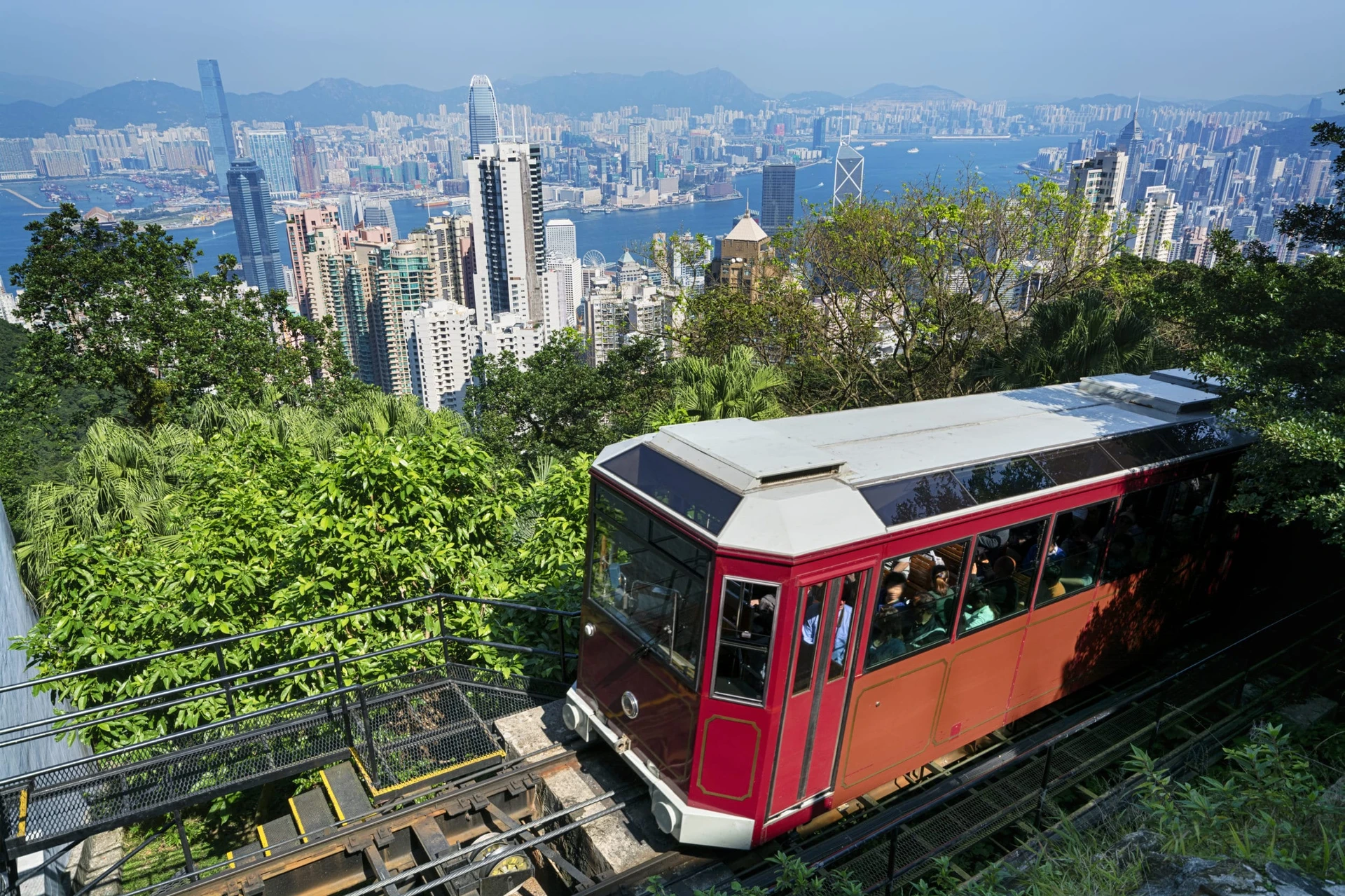 The Peak Tram going uphill with Hong Kong skyline in the background.