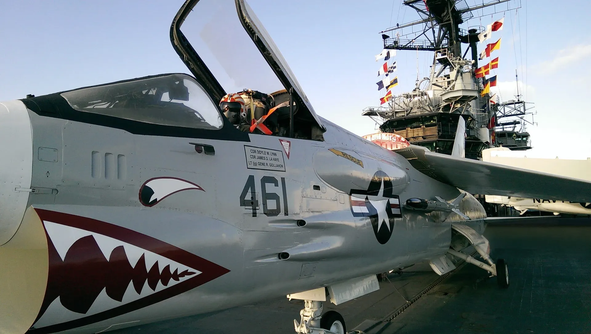 A military aircraft with an open cockpit sits on the deck of the USS Midway Museum.