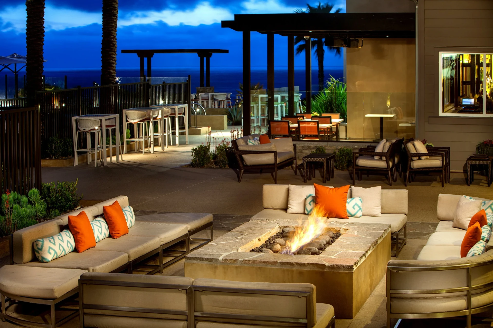 Outdoor patio with fire pit at night at Cape Rey Carlsbad