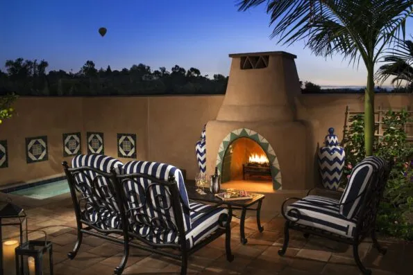 Suite patio with outdoor fireplace and lounge chairs.