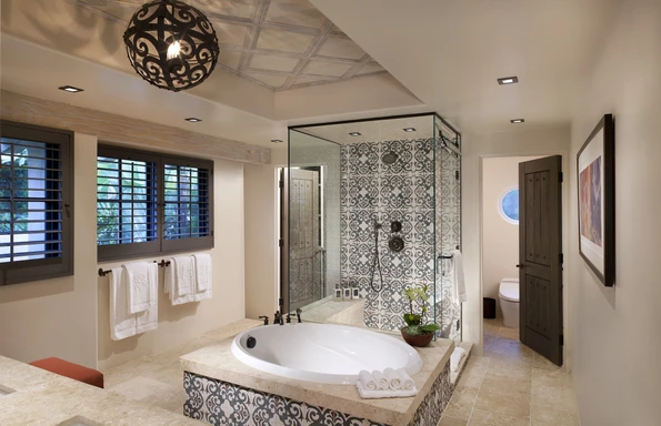 Bathtub and shower with pretty Spanish style tiles.