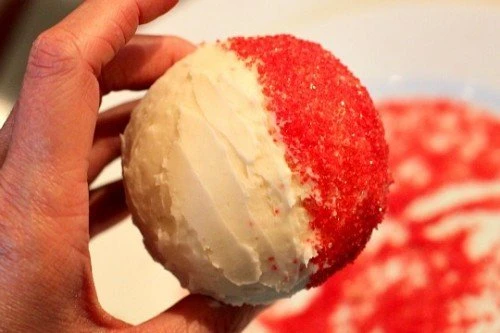 Almost 1/2 of the cupcake is dipped in sprinkles.