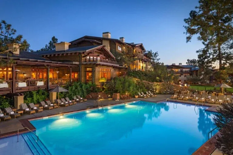 The Lodge at Torrey Pines building exterior and pool lit at dusk.