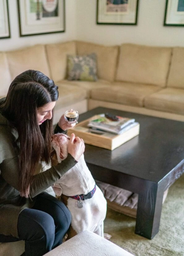 My dog looks at me while I hold a cup of coffee