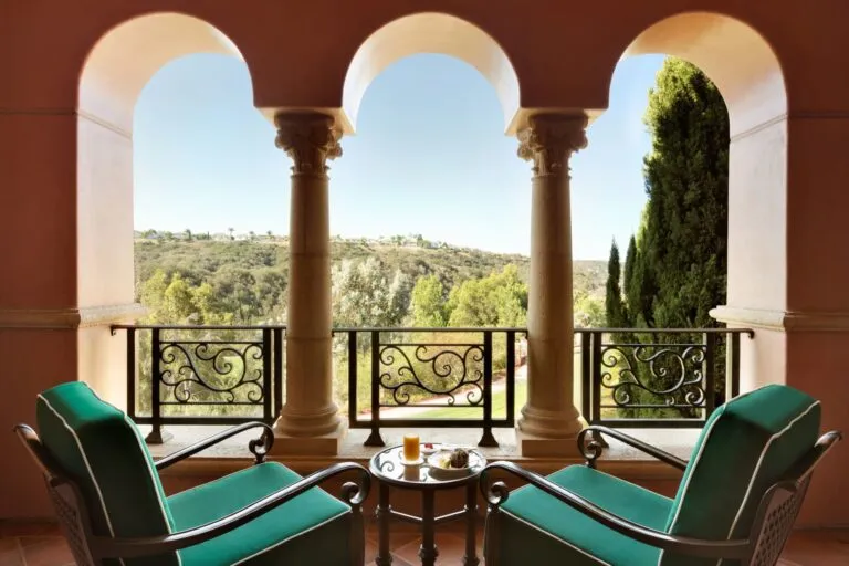 Two green lounge chairs on a Deluxe Veranda Room balcony overlooking the preserve.