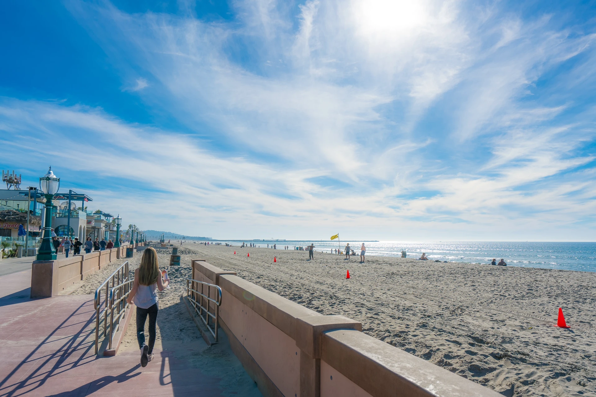 My daughter walks on to the beach from the boardwalk at Mission Beach