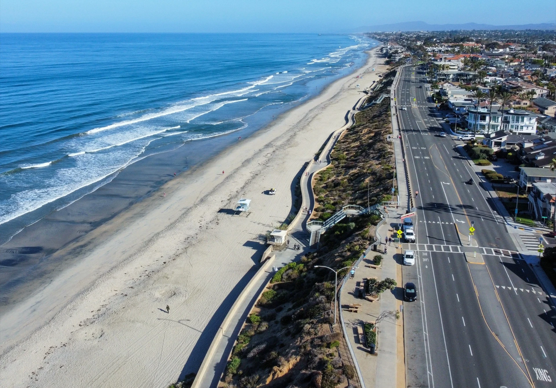Aerial view of Carlsbad State Beach in the morning with few people and cars.