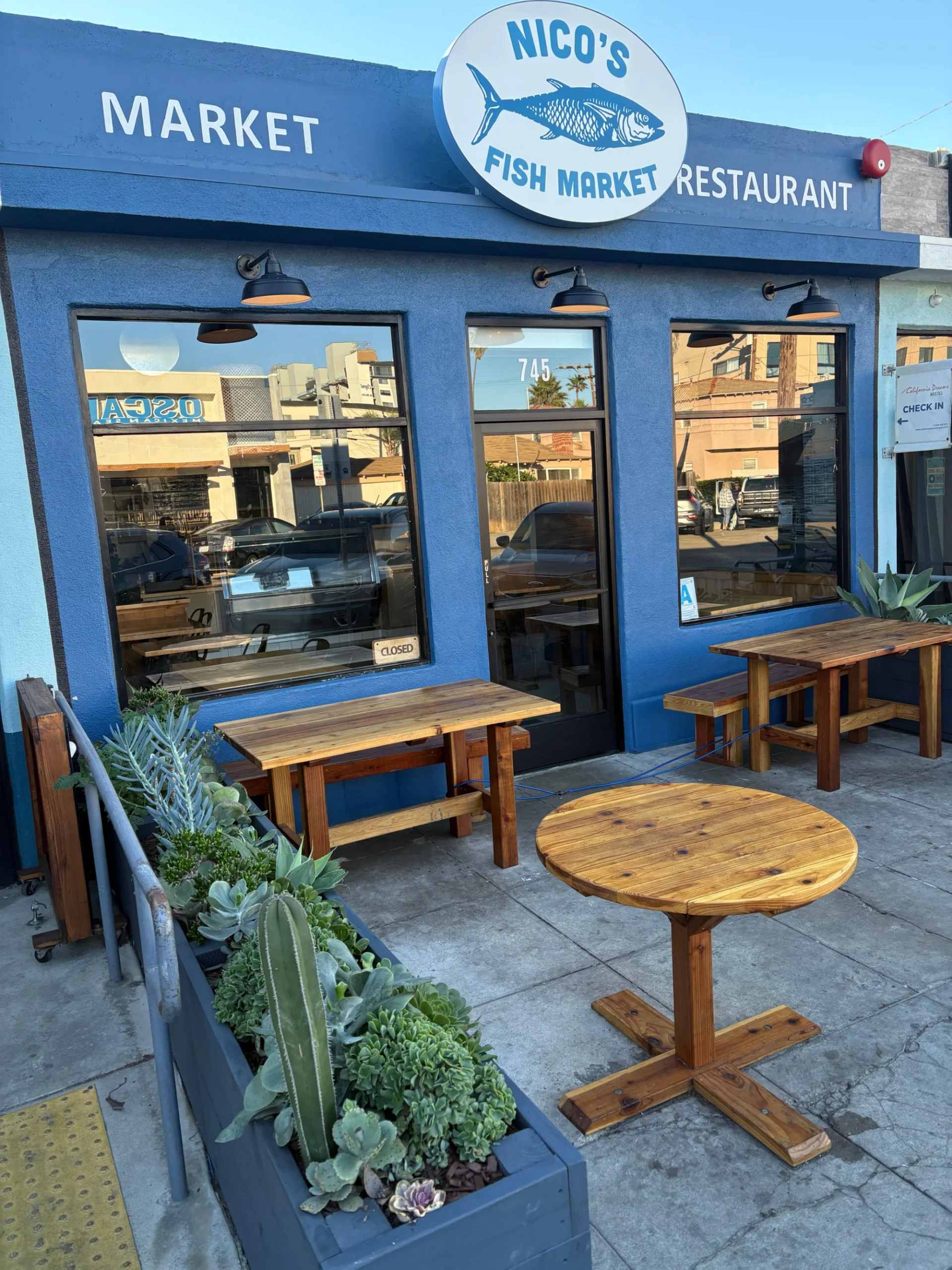 Nico's Fish Market exterior photo with wooden seating in front.