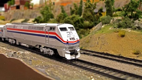 A model Amtrak train on a track in a display at San Diego Model Railroad Museum.