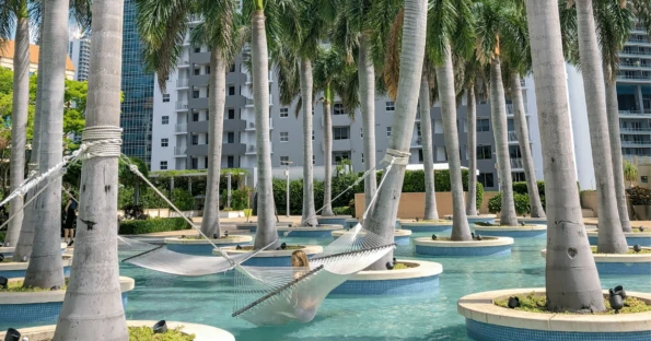 My daughter swings on a hammock above a pool at Four Seasons Miami.