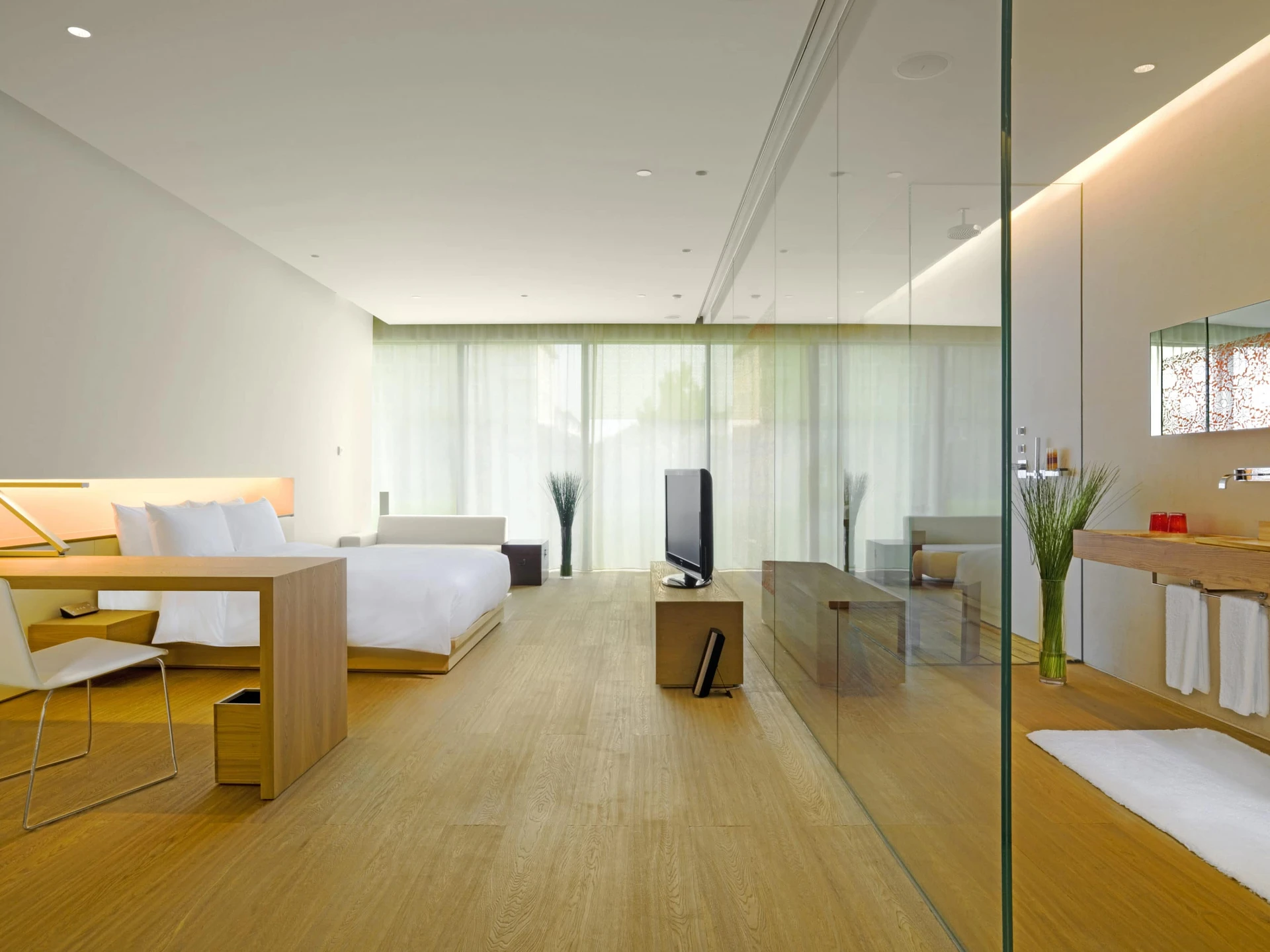 A room and bathroom divided by glass at The Opposite House.