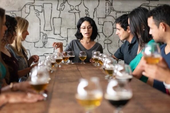 A So Diego tour guide explains to seated guests what's in their beer flights.