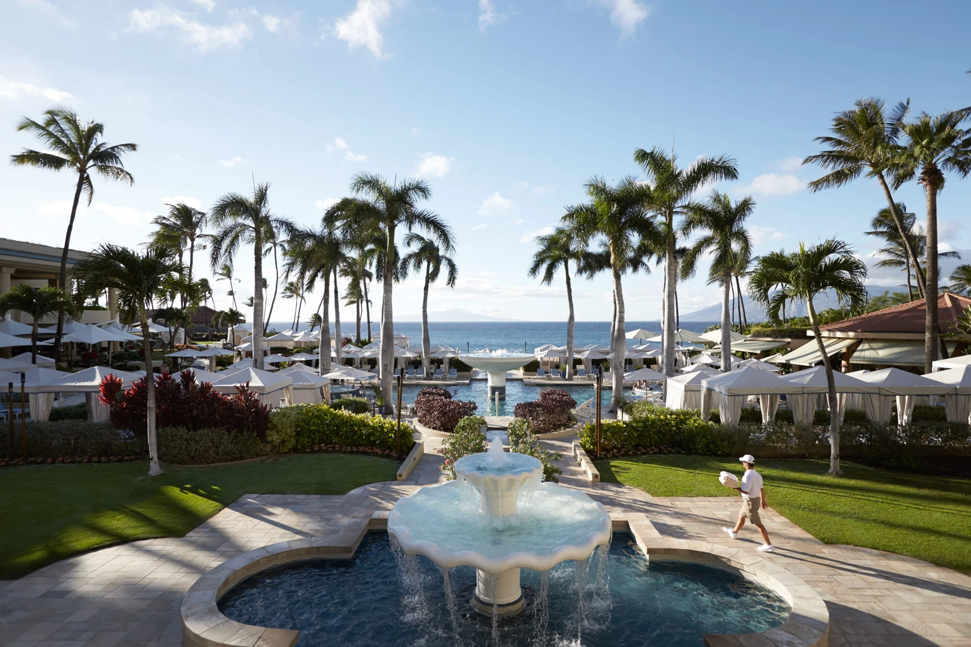 A pool attendant walks carries towels to the pool at Four Seasons Resort Maui at Wailea.