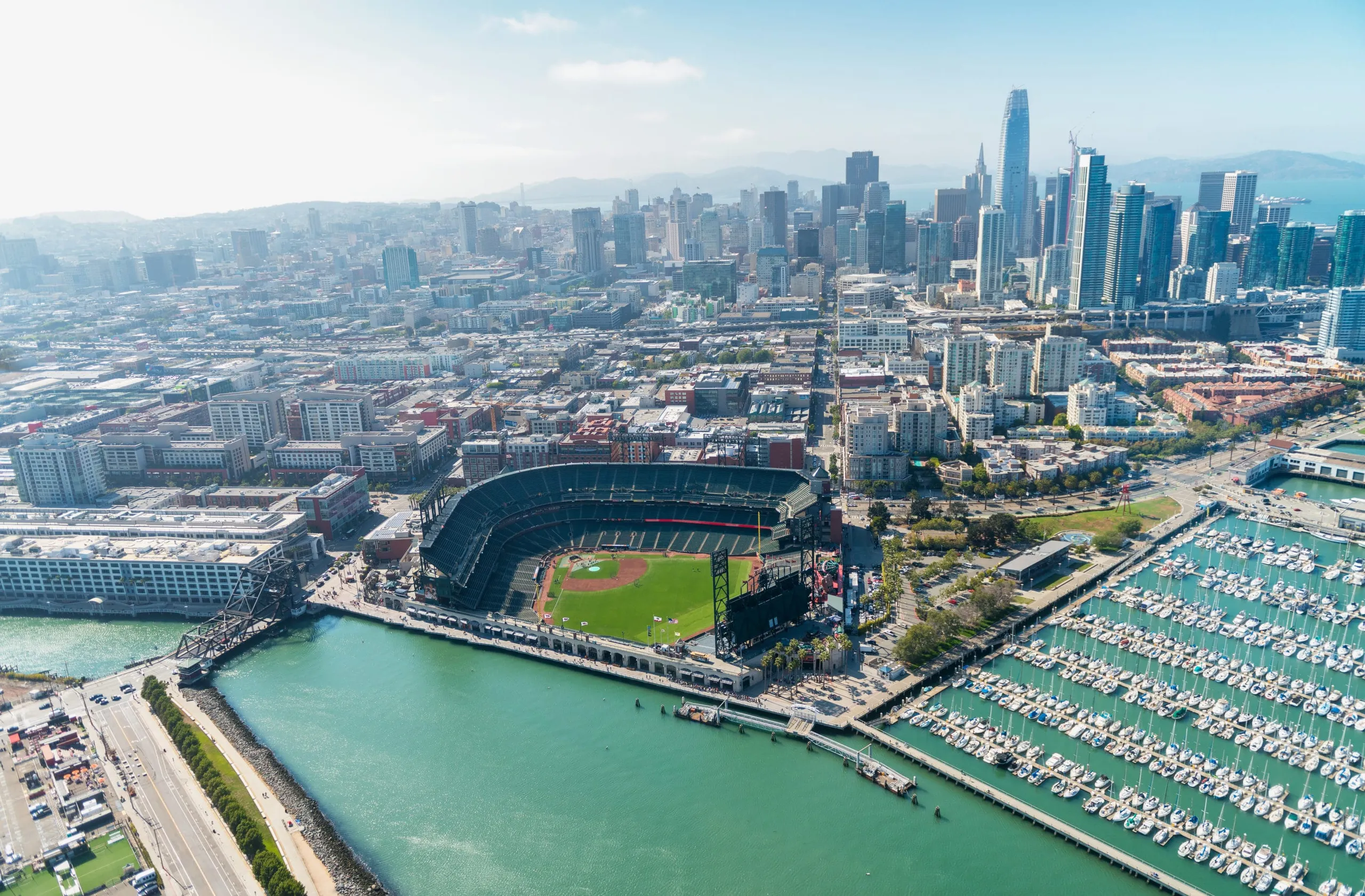 Aerial view of Oracle Park and the San Francisco skyline on a sunny day.