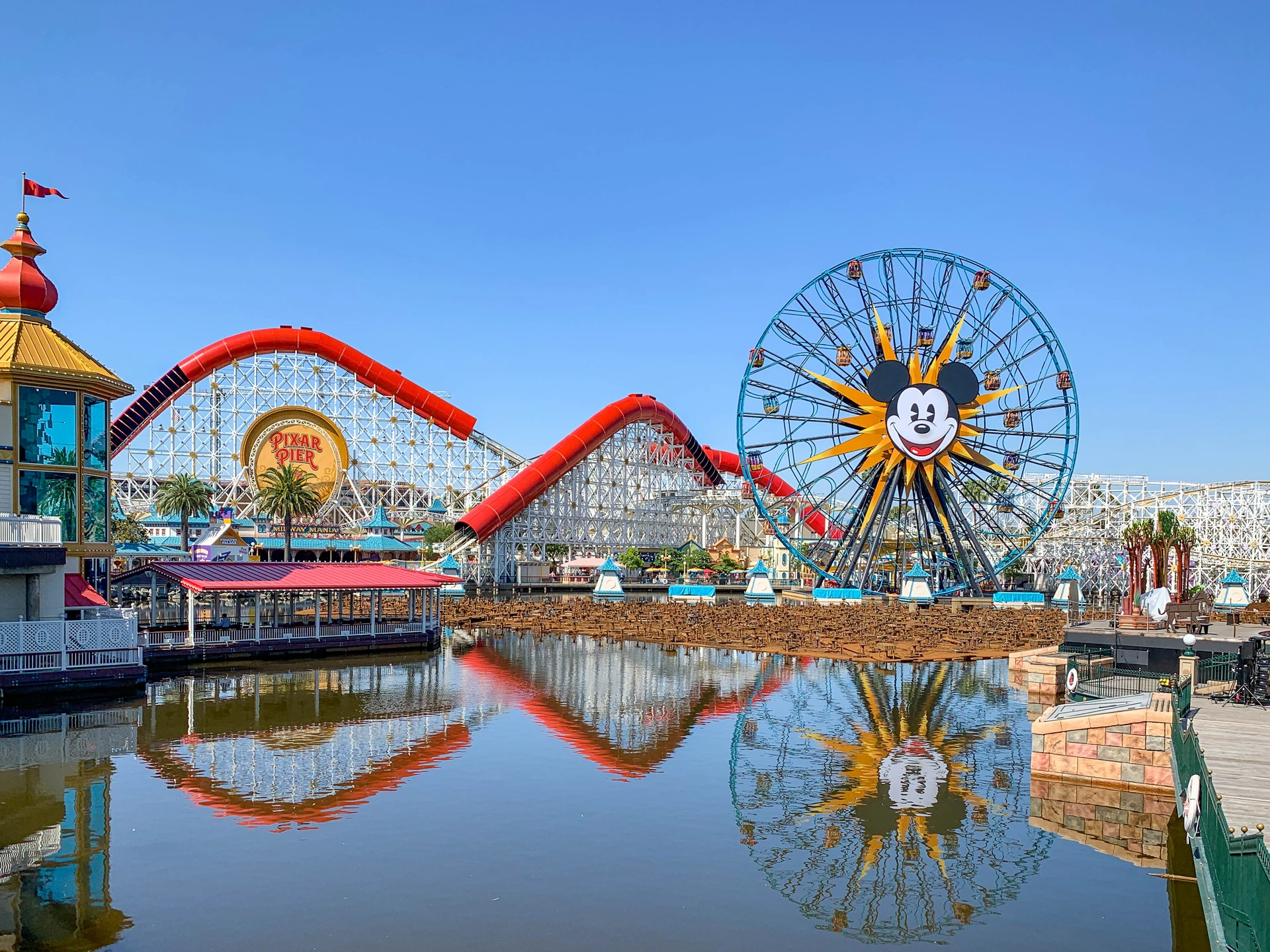 View of the Incredicoaster roller coaster and Pixar Pal-A-Round ferris wheel over the water.