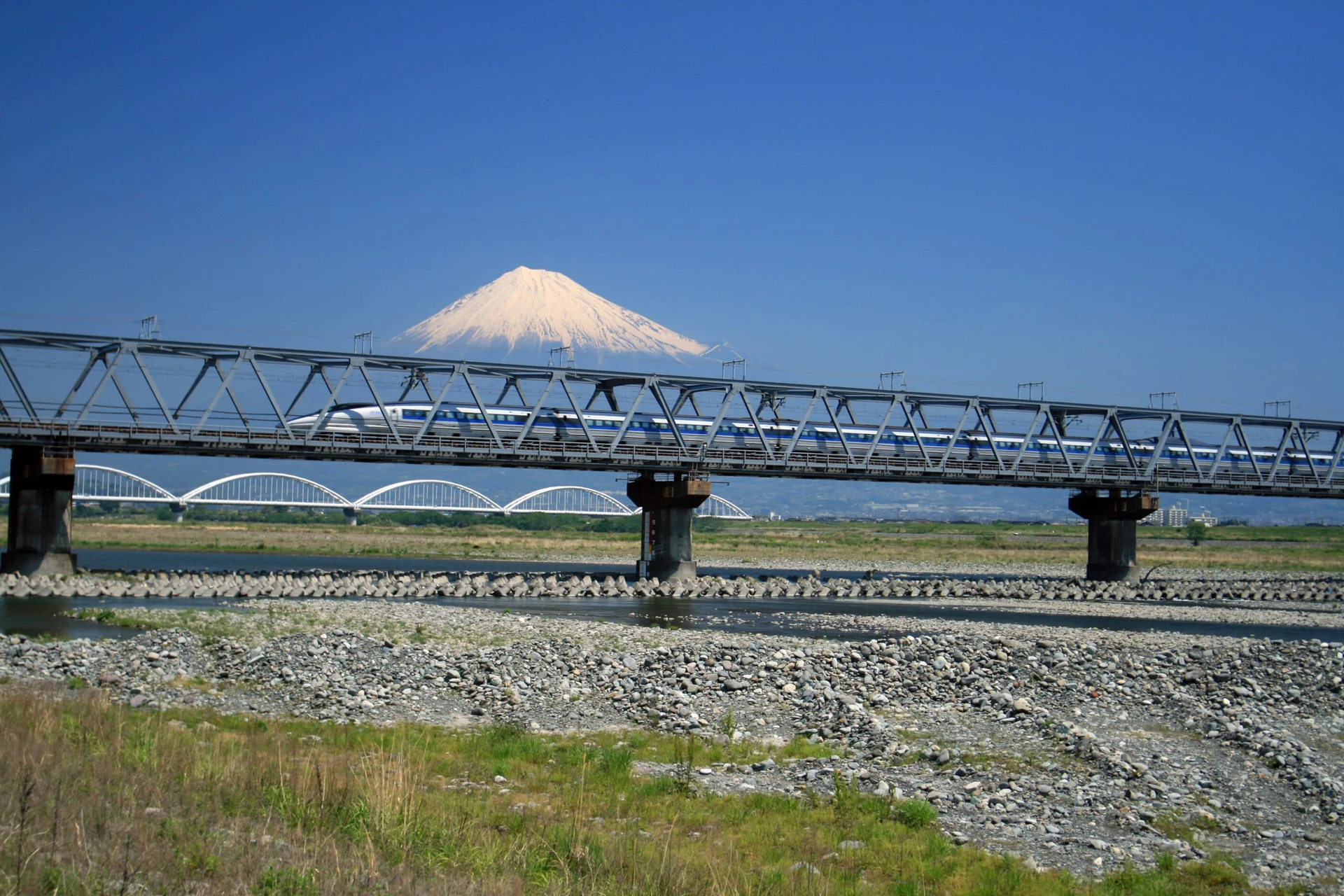 A shinkansen bullet train passing by Mt. Fuji
