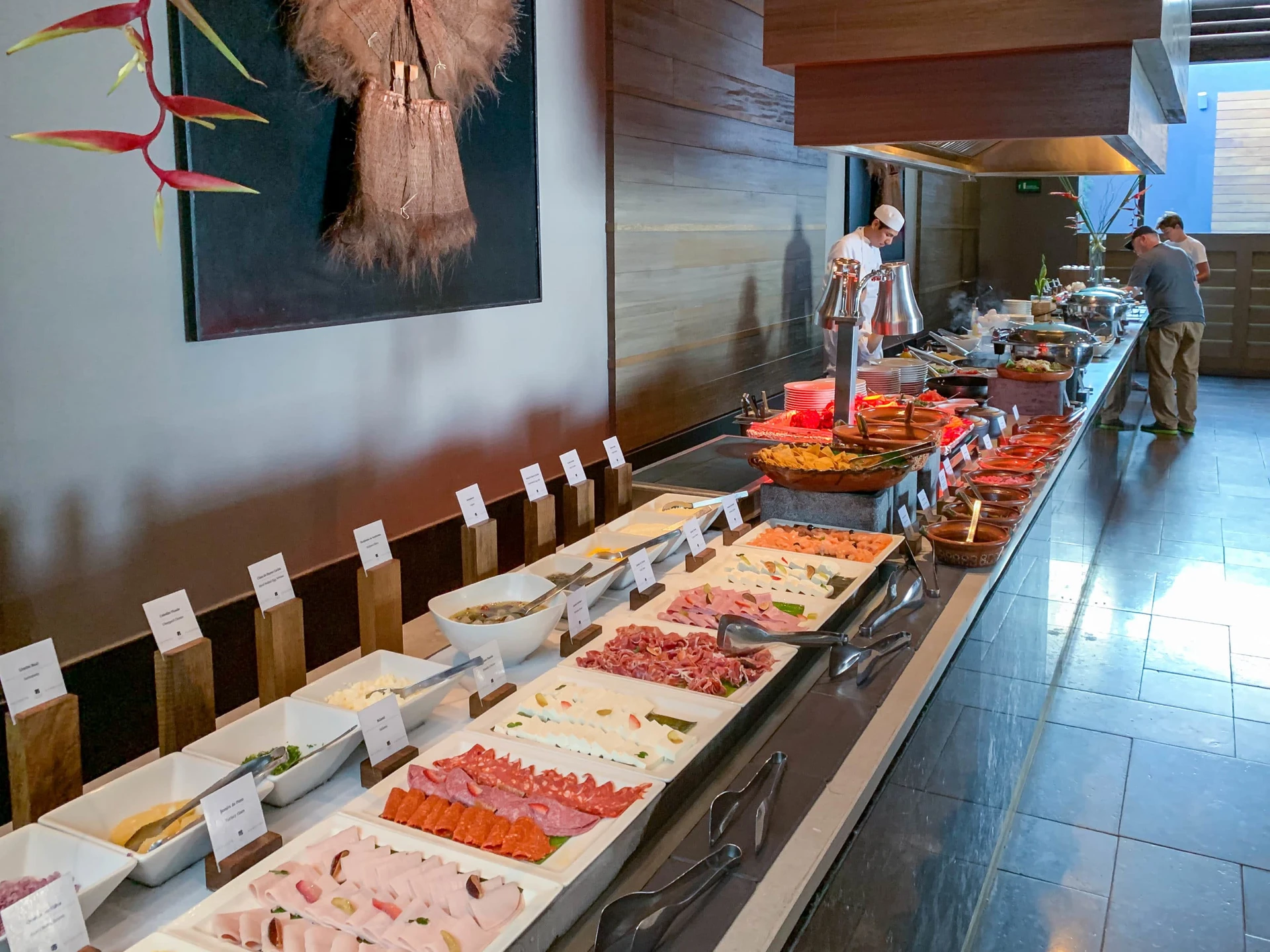 Part of the Nizuc breakfast buffet counter with cold cuts and a chef making pancakes.