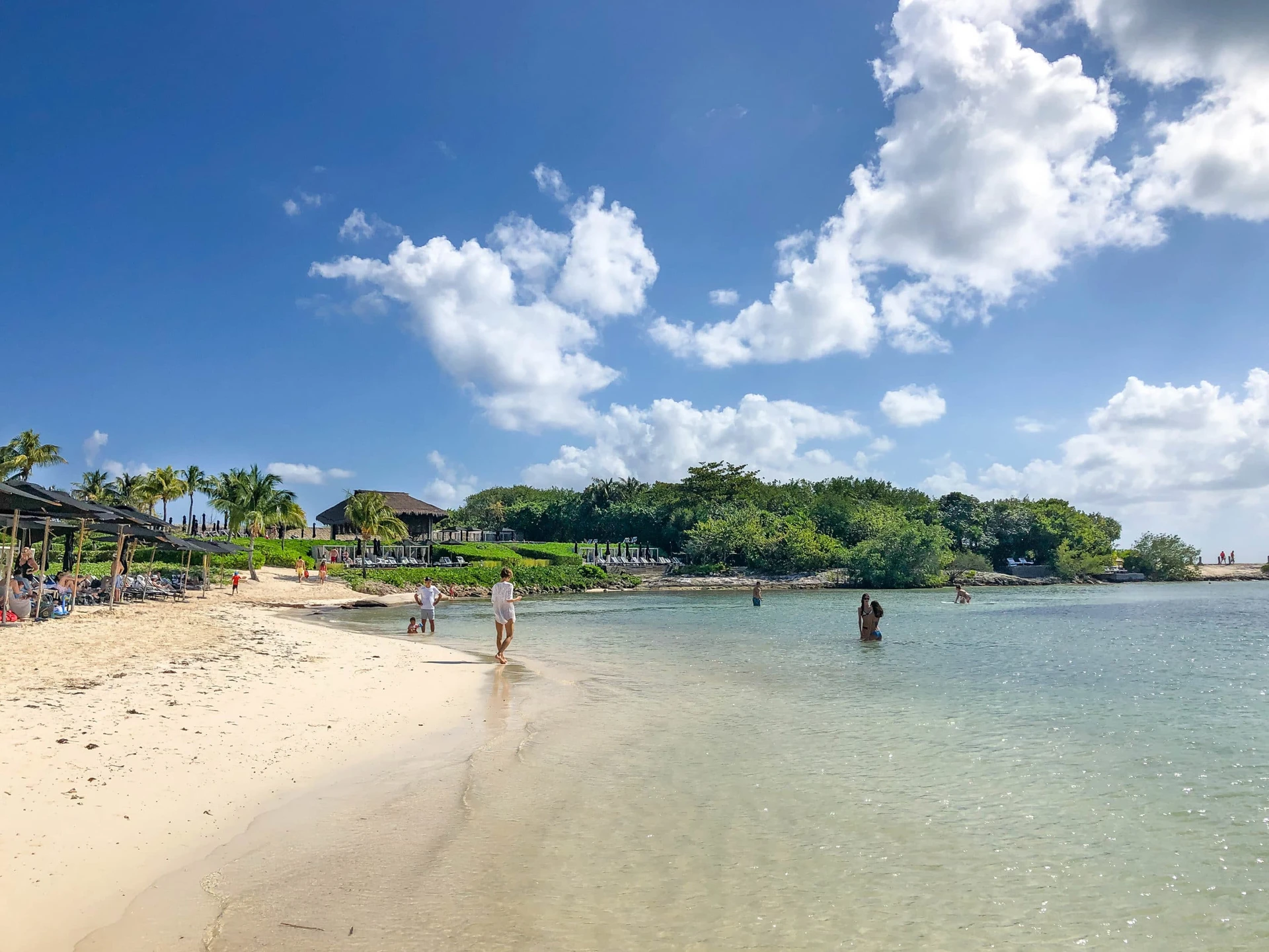People enjoy the beach at the water's edge.